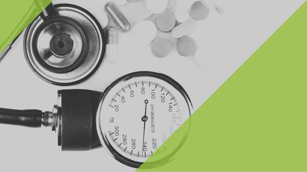 Pressure display of a blood pressure monitor and some pills scattered next to it